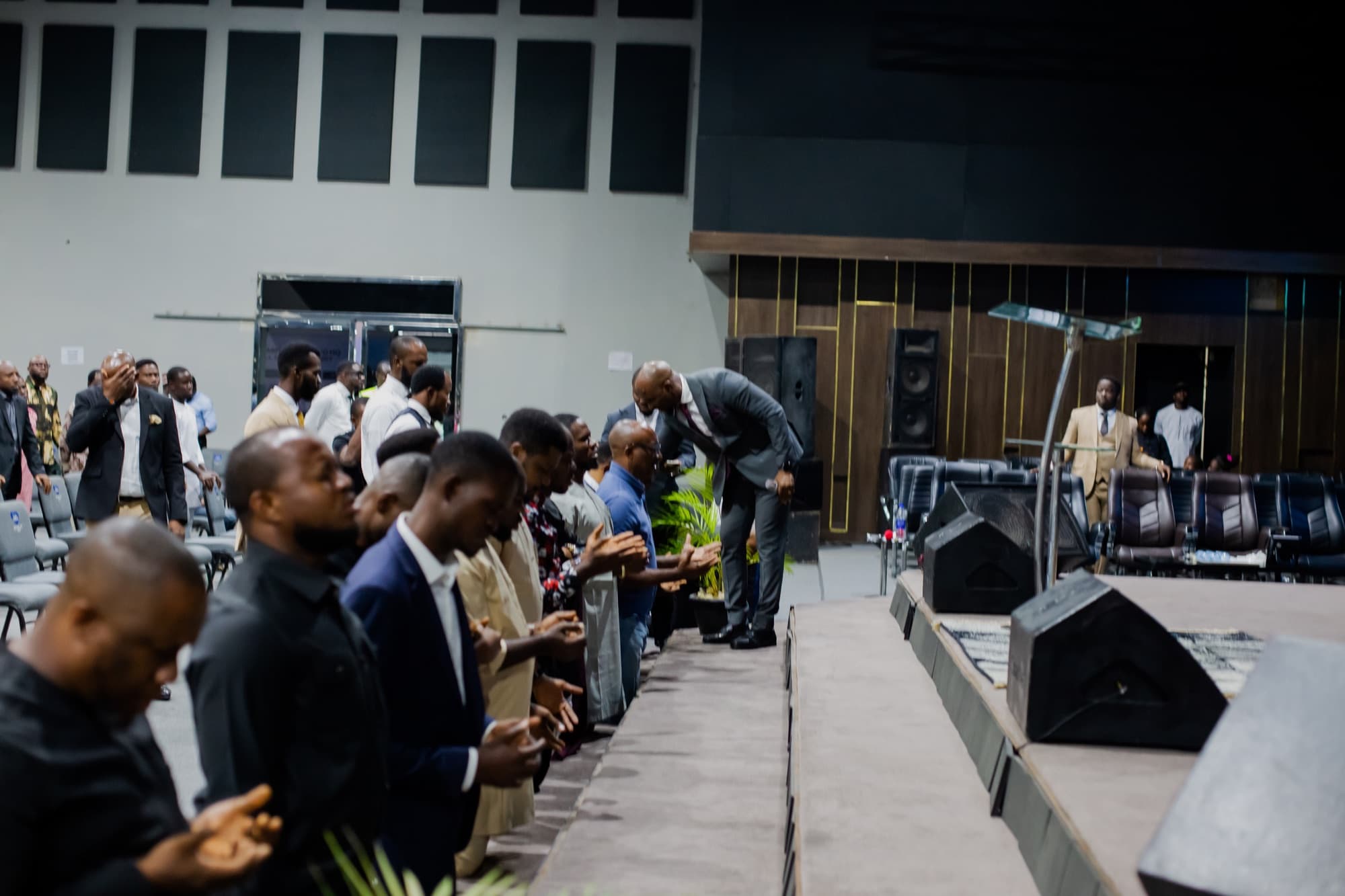 Brothers kneeling in prayer at the Men's Convention